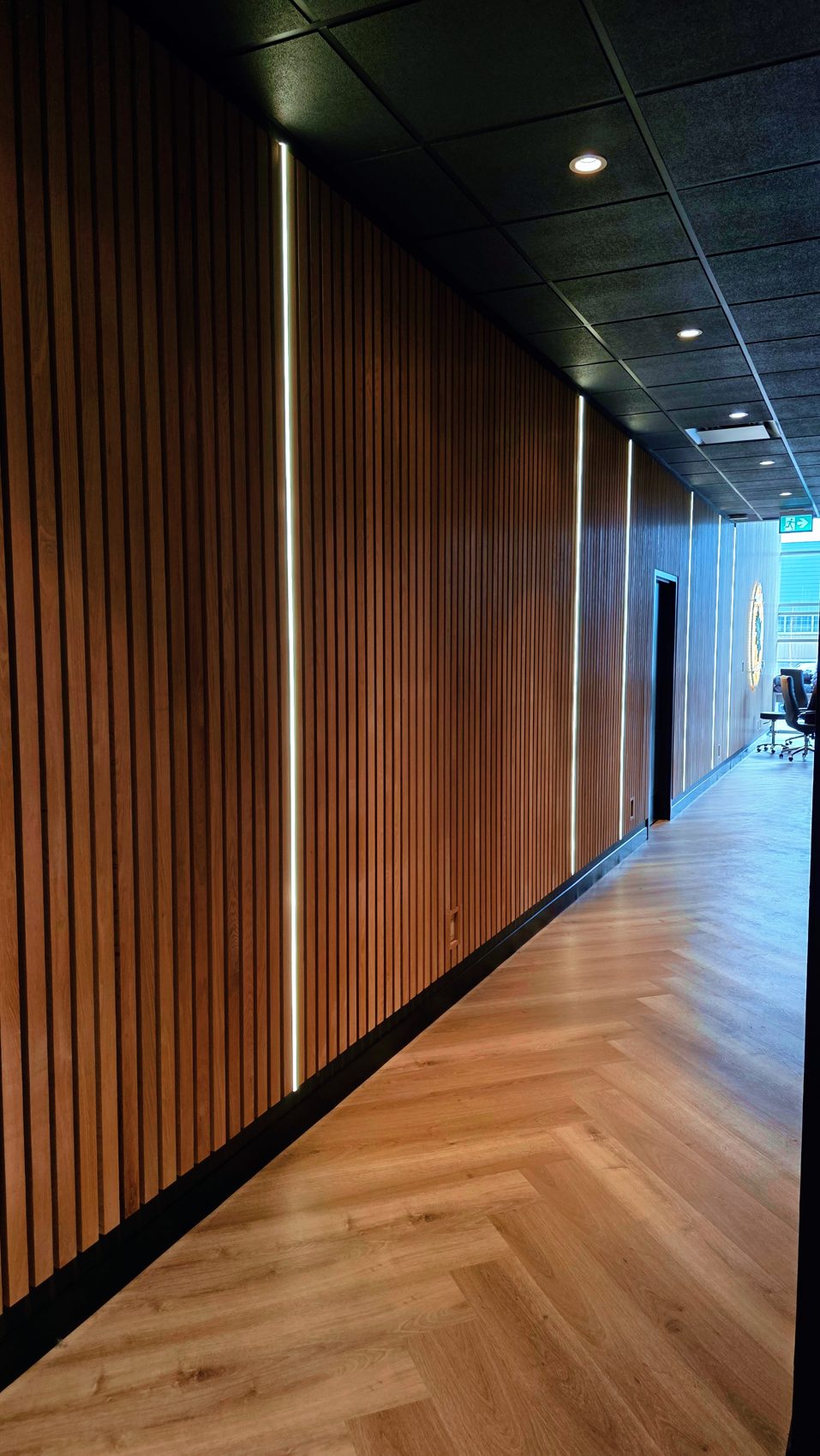 Lit timber-slat corridor in a wellness clinic